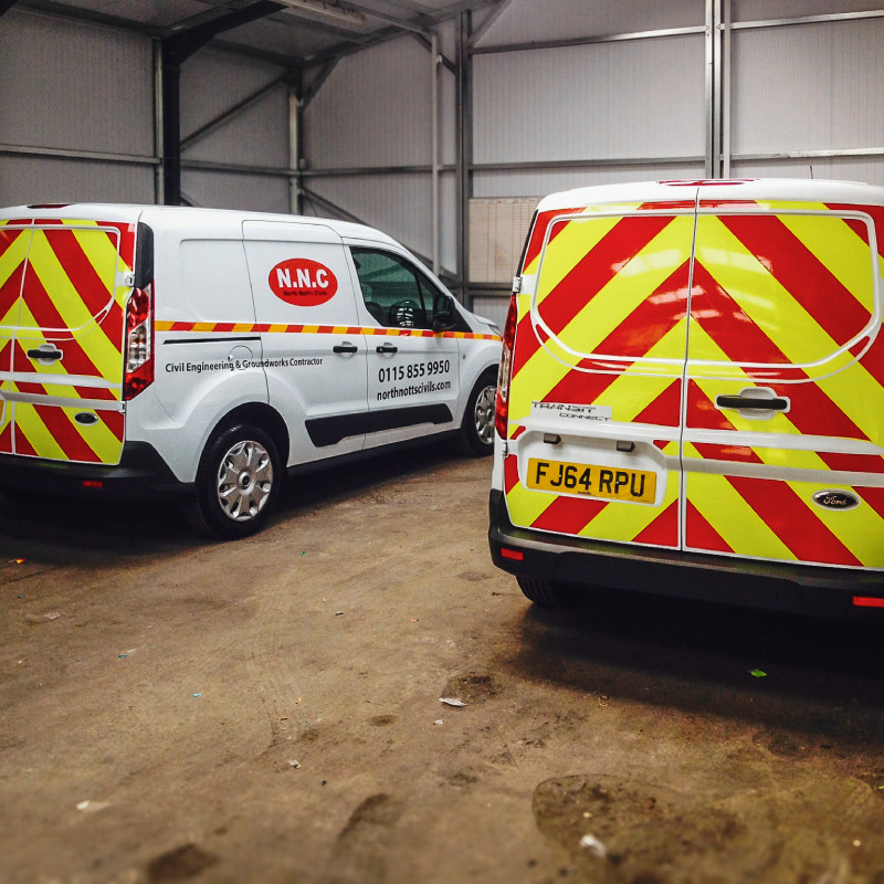 White Van with reflective yellow and red chevrons on the back doors. The side features a reflective strip, NNC Logo and their slogan.