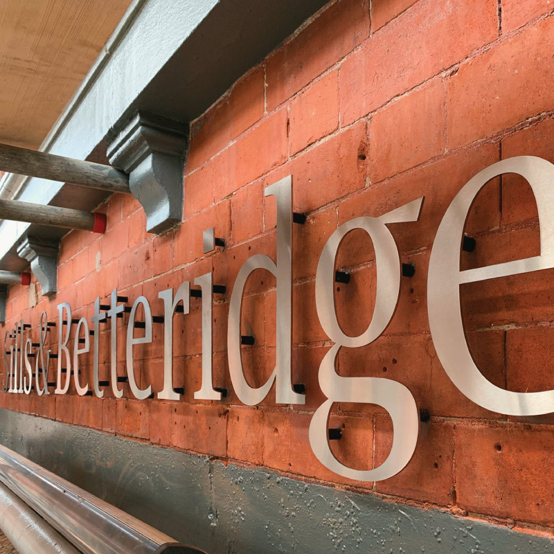 Silver flat cut lettering which is attached to the walls with standoff posts creating a more high end look than regular flat cut lettering.