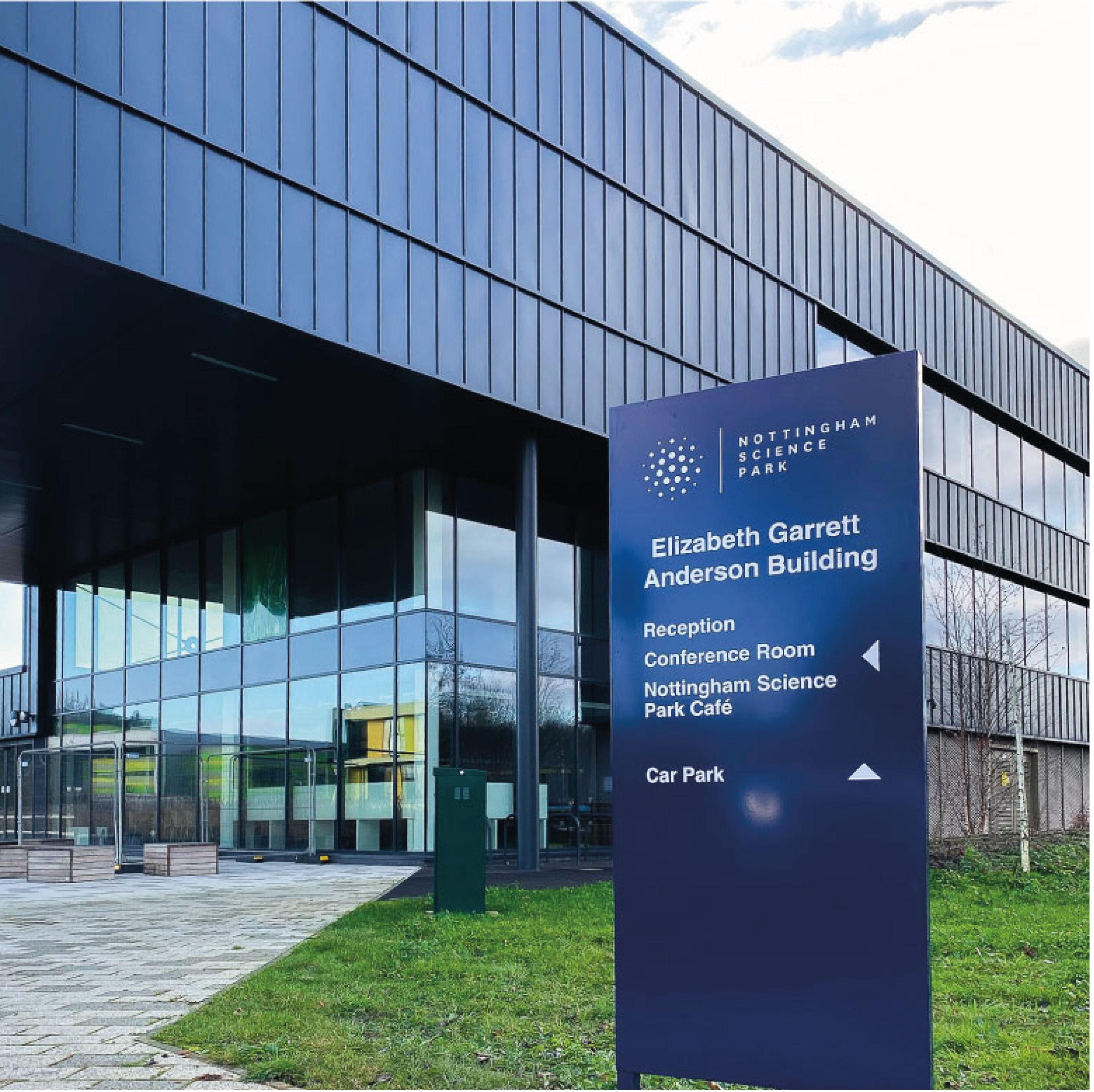 Blue directional sign infront of modern building