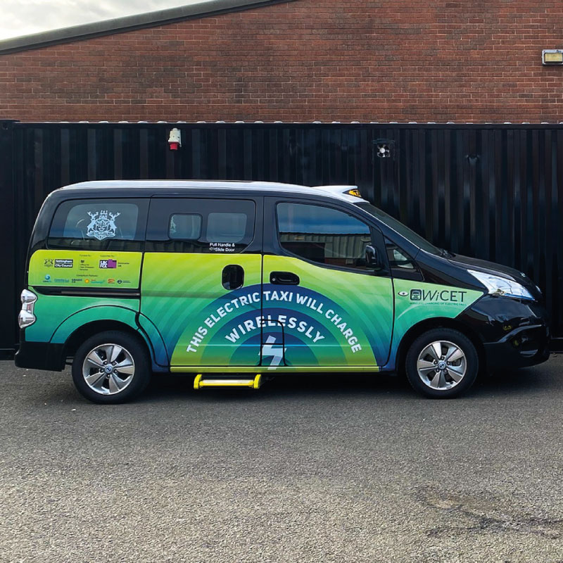 Black taxi cab with green, blue and yellow gradient graphics in circles moving outwards